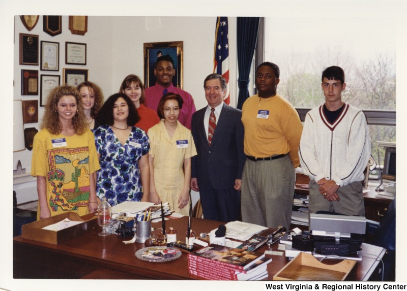 Representative Nick J. Rahall (D-W.Va.) stands for a photograph with eight unidentified Logan County, WV school students in his office.