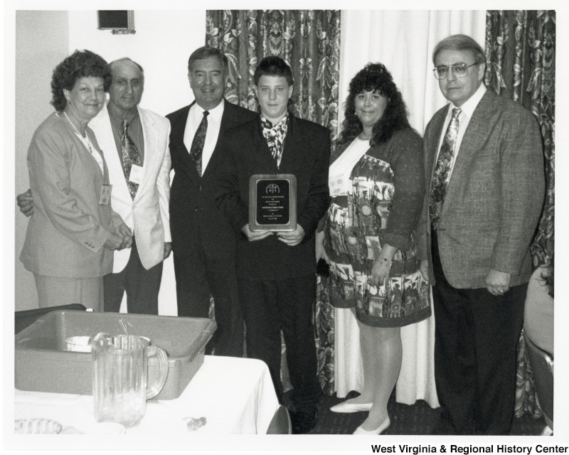 Congressman Nick Rahall (D-WV) with a group of unidentified people on his office. An unidentified boy is holding a plaque.