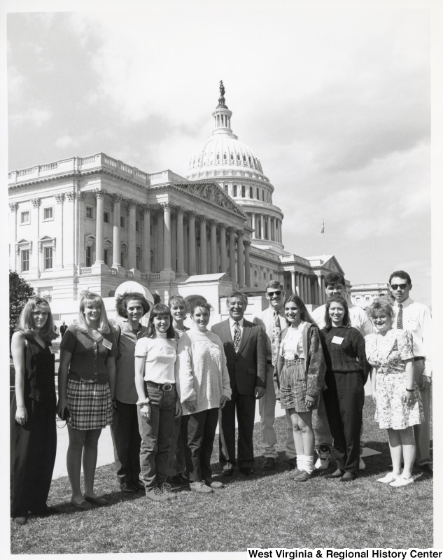 In the center, Representative Nick J. Rahall (D-W.Va.) stands with a school group for a photograph outside the United States Capitol building.