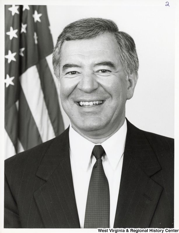 Representative Nick J. Rahall (D-W.Va.) smiles for a portrait in front of an American flag.