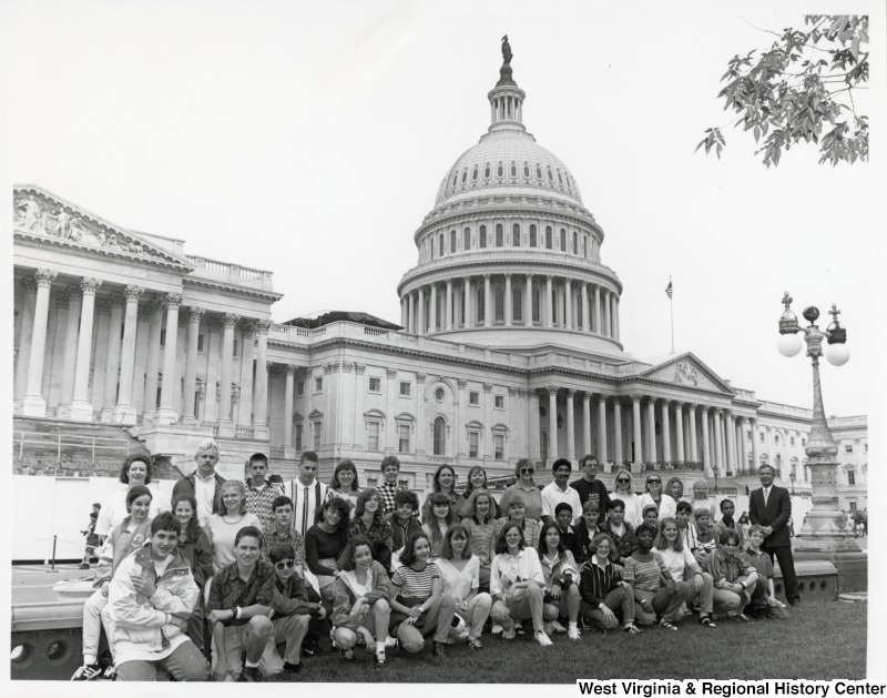 On the far right, Representative Nick J. Rahall (D-W.Va.) stands with an unidentified group of students from St. Joe's School in front of the United States Capitol building.