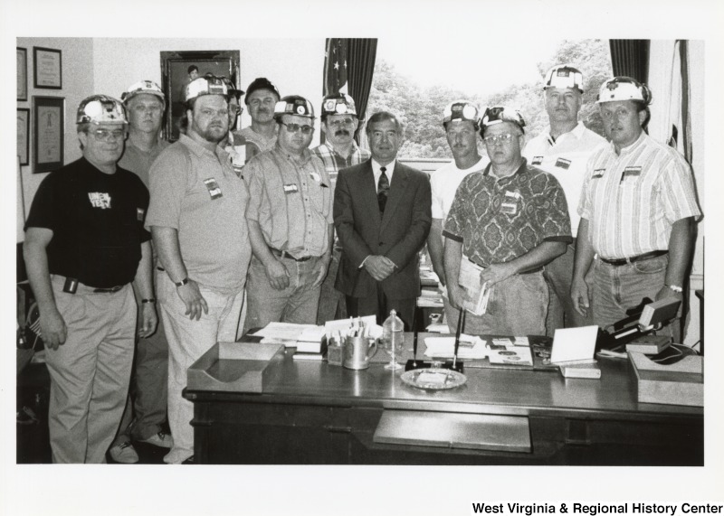 Representative Nick J. Rahall (D-W.Va.) stands for a photograph with a group of men from the United Mine Workers of America.