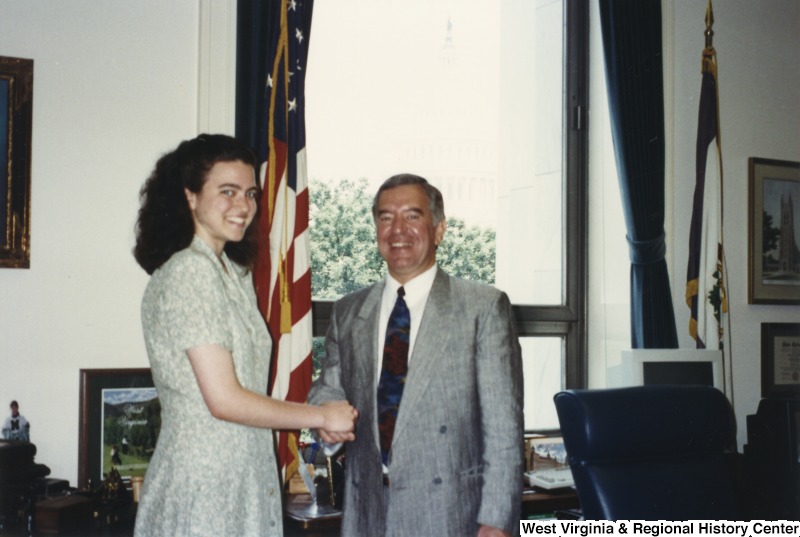 On the right, Representative Nick J. Rahall (D-W.Va.) shakes hands with an unidentified woman.