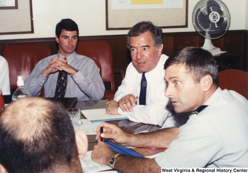 Representative Nick J. Rahall (D-W.Va.) sits between two unidentified members of the Army Corps of Engineers.