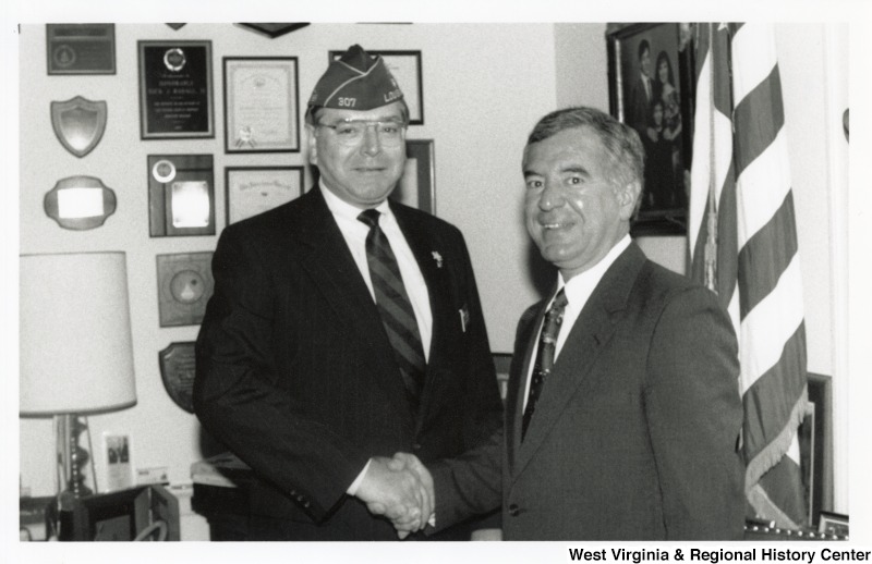 On the right, Representative Nick J. Rahall (D-W.Va.) shakes hands with William Detweiler, the National Commander of the American Legion.