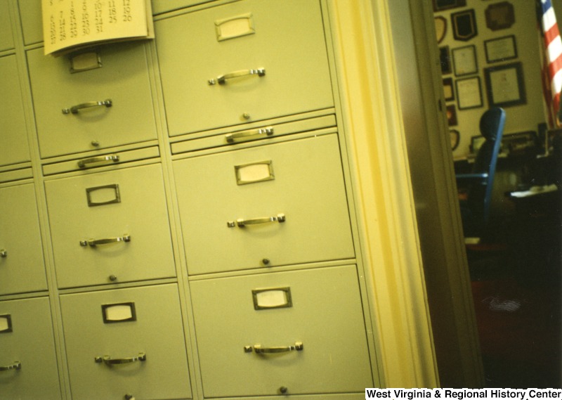 This is a photograph of a filing cabinet in front of a doorway to an office.