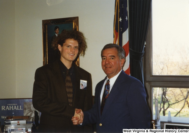 On the right, Representative Nick J. Rahall (D-W.Va.)  shakes hands with an unidentified man.