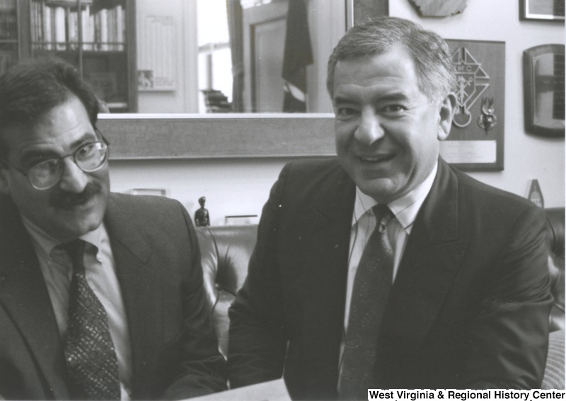 On the right, Representative Nick J. Rahall (D-W.Va.) sits next to an unidentified man.