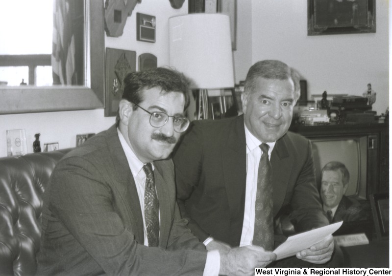 On the right, Representative Nick J. Rahall (D-W.Va.) sits next to an unidentified man.