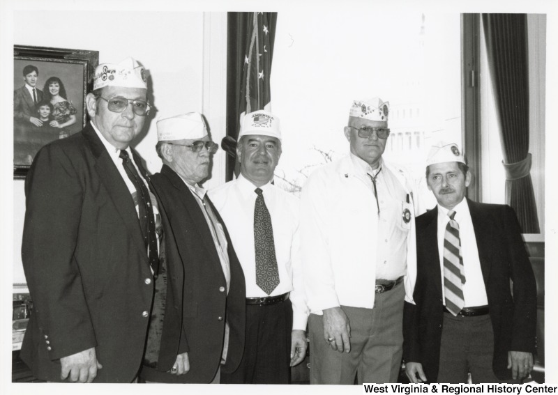 In the center of four unidentified men of the Veterans of Foreign Wars (VFW), Representative Nick J. Rahall (D-W.Va.) stands for a photograph wearing a VFW hat.