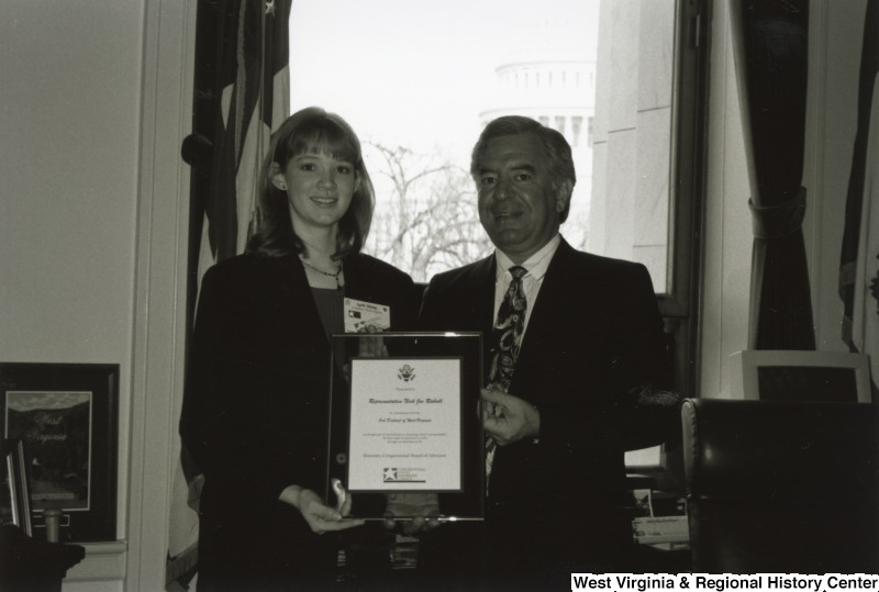 On the right, Representative Nick J. Rahall (D-W.Va.) holds an award and stands for a photograph with April Shimp of the National Young Leaders Conference.