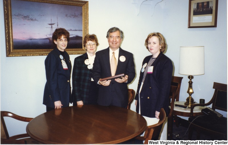 Congressman Nick Rahall (D-WV) with three unidentified women wearing large buttons in his D.C. office.
