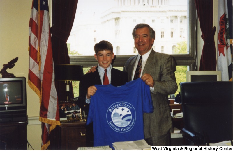 Congressman Nick Rahall (D-WV) holding a National Young Leaders Forum shirt with an unidentified young person in his D.C. office.