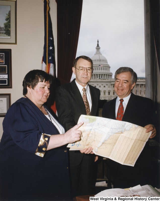 Congressman Nick Rahall (D-WV) looking at a map with Federal Highway Administration administrator Ken Wykle and an unidentified woman in his D.C. office.