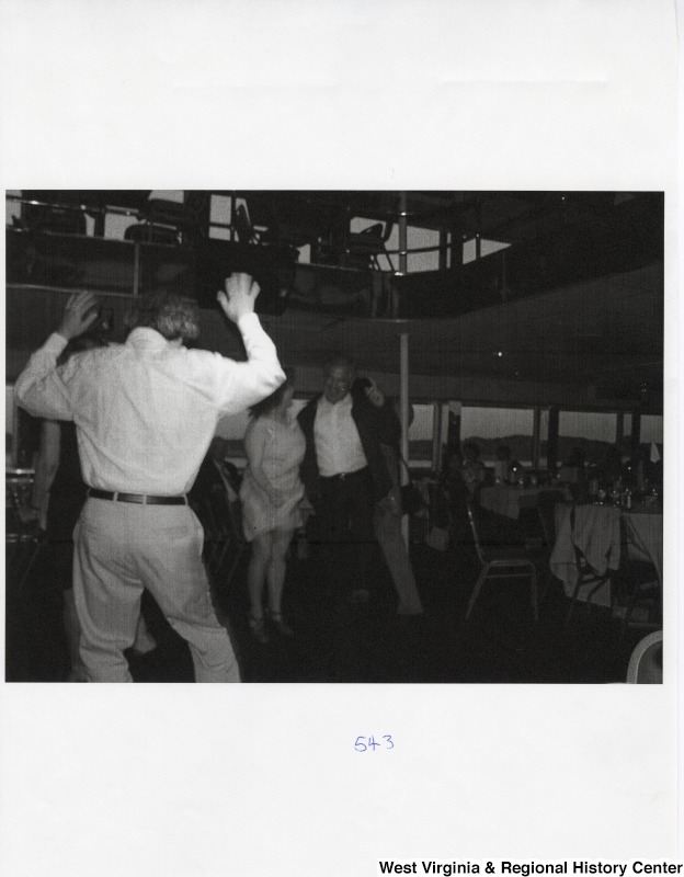 Three unidentified people dance at a party.