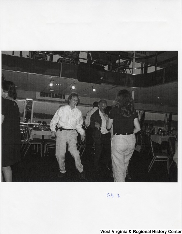 Several people dance together on a dance floor at a party.