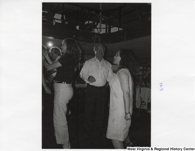 In the center, Representative Nick J. Rahall (D-W.Va.) dances with four unidentified people on a dance floor at a party.