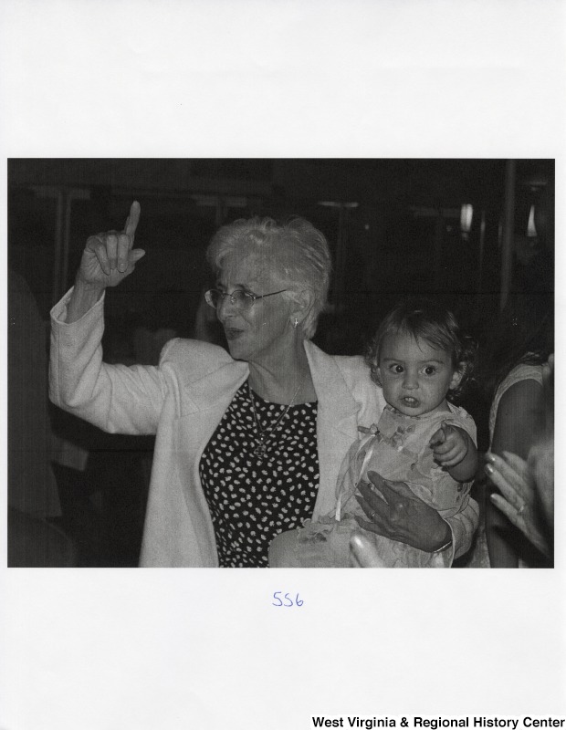 An unidentified woman holds an unidentified child at a party.