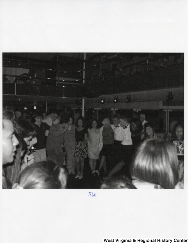 A large crowd of unidentified people dances together at a party.