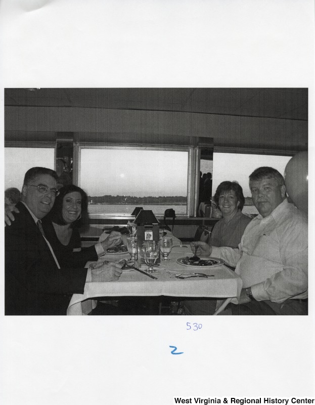 Four unidentified people sit around a dinner table in a public place.