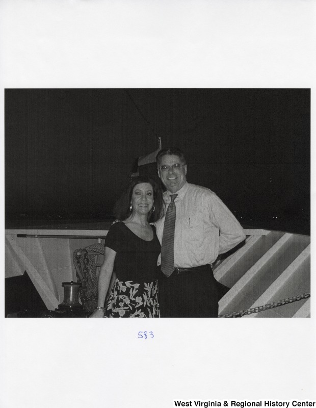An unidentified man and an unidentified woman smile for a photograph on a boat.