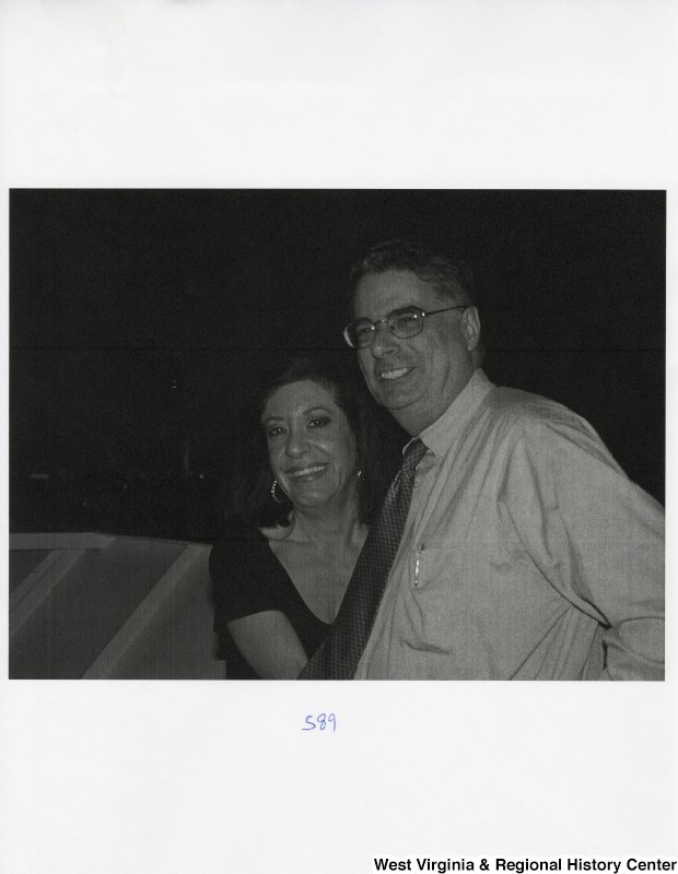 An unidentified man and an unidentified woman stand for a picture on a boat during a party.
