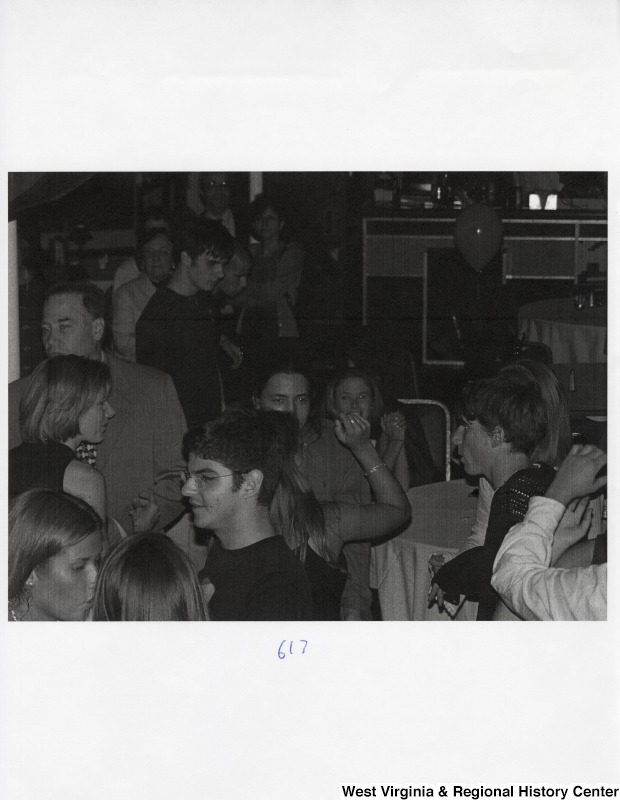 A large group of unidentified people mingle at a party.