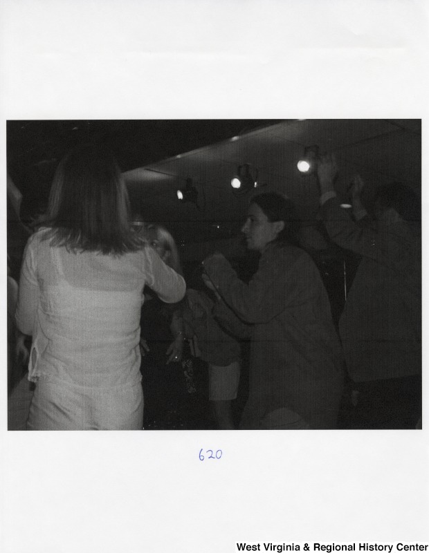 A large group of unidentified people dance together at a party.