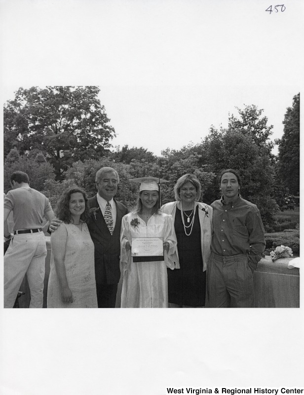 L-R: Rebecca Rahall, Representative Nick J. Rahall (D-W.Va.), Suzanne Rahall, unidentified woman, unidentified manThese five stand for a photograph outside while Suzanne Rahall wears graduation regalia.