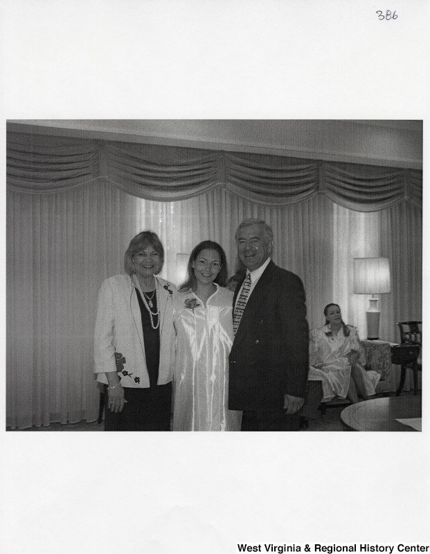 L-R: unidentified woman, Suzanne Rahall, Representative Nick J. Rahall (D-W.Va.) The three stand for a photograph while Suzanne wears a graduation gown.