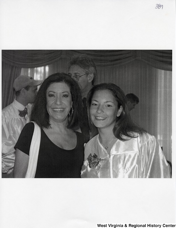 On the right, Suzanne Rahall, wearing a graduation gown, smiles for a photograph with an unidentified woman.