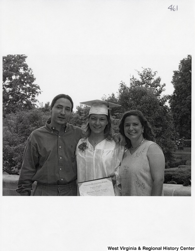 L-R: unidentified young man, Suzanne Rahall, Rebecca RahallThe three stand outside for a photograph while Suzanne wears her graduation regalia.