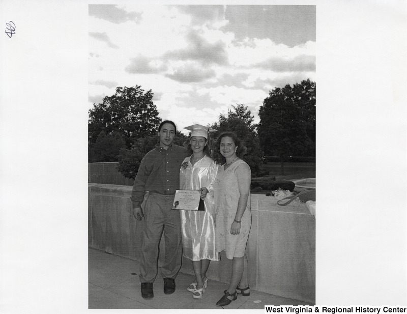 L-R: unidentified young man, Suzanne Rahall, Rebecca RahallThe three stand outside for a photograph while Suzanne wears her graduation regalia.