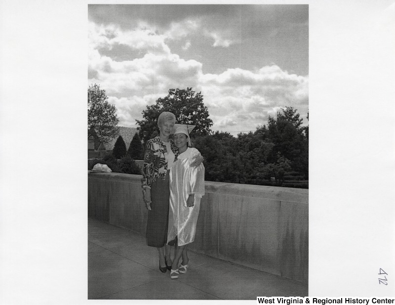 On the right, Suzanne Rahall stands for a photograph with an unidentified woman while she wears her graduation regalia.