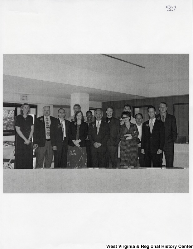 In the middle, Representative Nick J. Rahall (D-W.Va.) stands for a photograph with a group of unidentified people at an event.