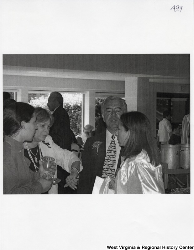 Representative Nick J. Rahall (D-W.Va.) talks with a group of unidentified people at an event.