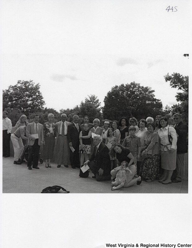 In the center, Representative Nick J. Rahall (D-W.Va.) stands in a group of unidentified people while Suzanne Rahall wears her graduation regalia.
