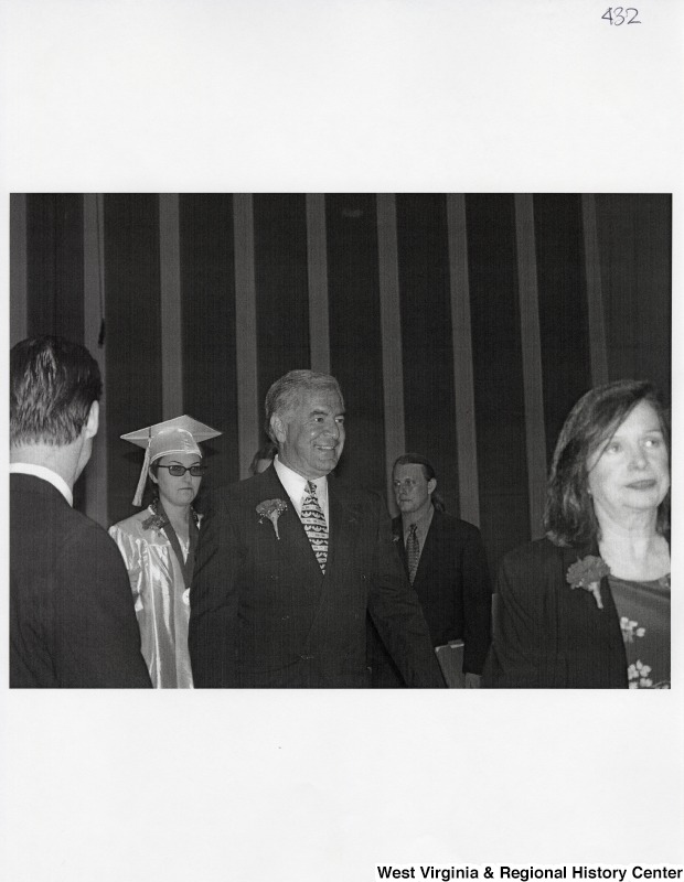Representative Nick J. Rahall (D-W.Va.) smiles and walks in front of the camera at a commencement ceremony.