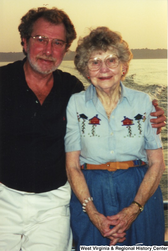 An unidentified man and an unidentified woman smile for a photograph on a boat.