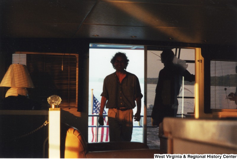 Two unidentified men stand on a boat.