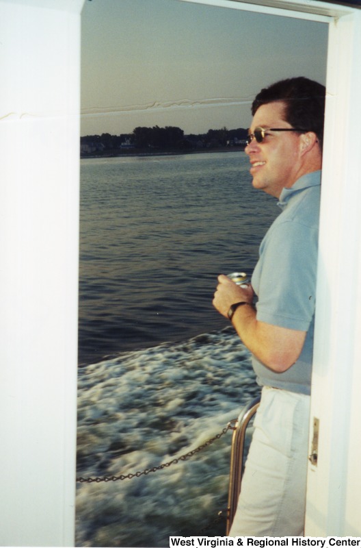 An unidentified man stands on a boat.