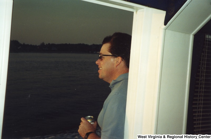 An unidentified man stands on a boat.