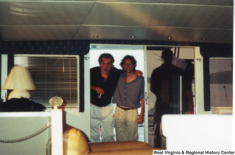 Three unidentified men stand on a boat.