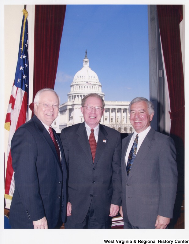 On the right, Representative Nick J. Rahall (D-W.Va.) stands next to two unidentified men in his office.
