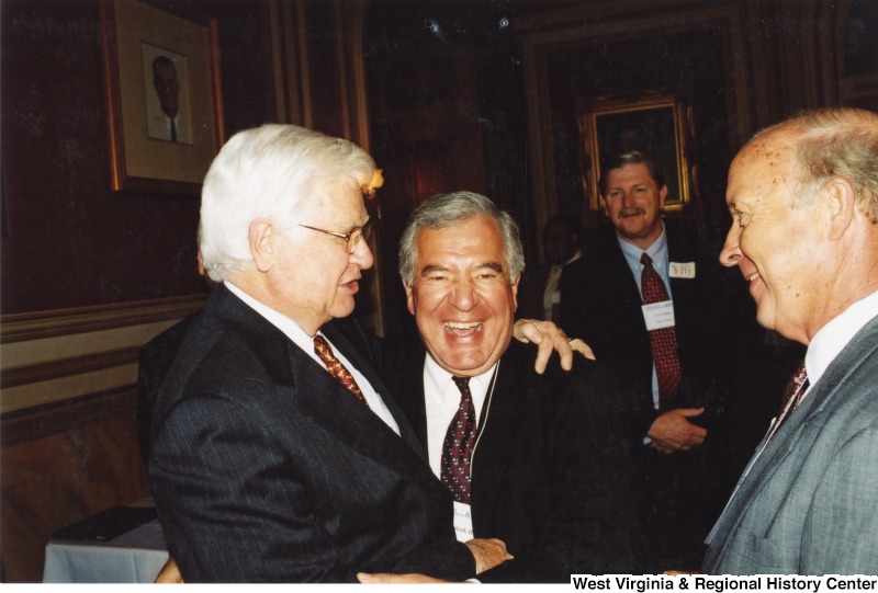 Congressman Nick Rahall (D-WV) laughing with Congressman Hal Rogers (R-KY) (left) and an unidentified man. An unidentified man can be seen in the background between Congressman Rahall and the unidentified man.