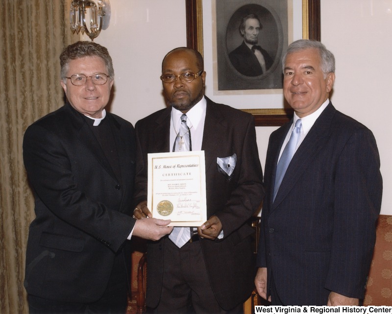 Congressman Nick Rahall (D-WV) holding a certificate with Reverend David Allen and an unidentified man.