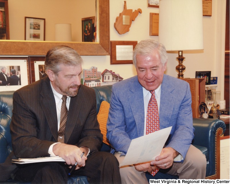 Congressman Nick Rahall (D-WV) looking at a paper with an unidentified man in his D.C. office.