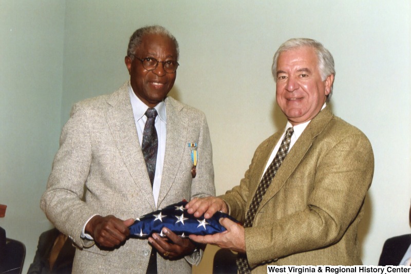Congressman Nick Rahall (D-WV) awarding a United States flag to an unidentified man at an event in Bramwell, West Virginia.
