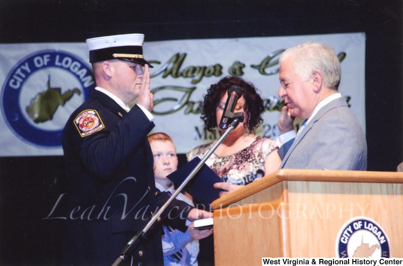 Congressman Nick Rahall (D-WV) swearing in an unidentified officer at the City of Logan Mayor and Council Inauguration.