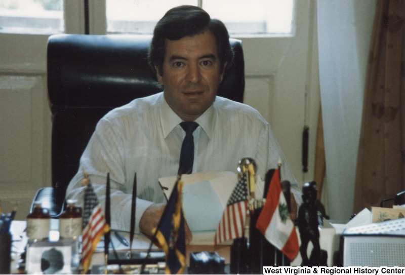Representative Nick J. Rahall (D-W.Va.) sits behind a desk.